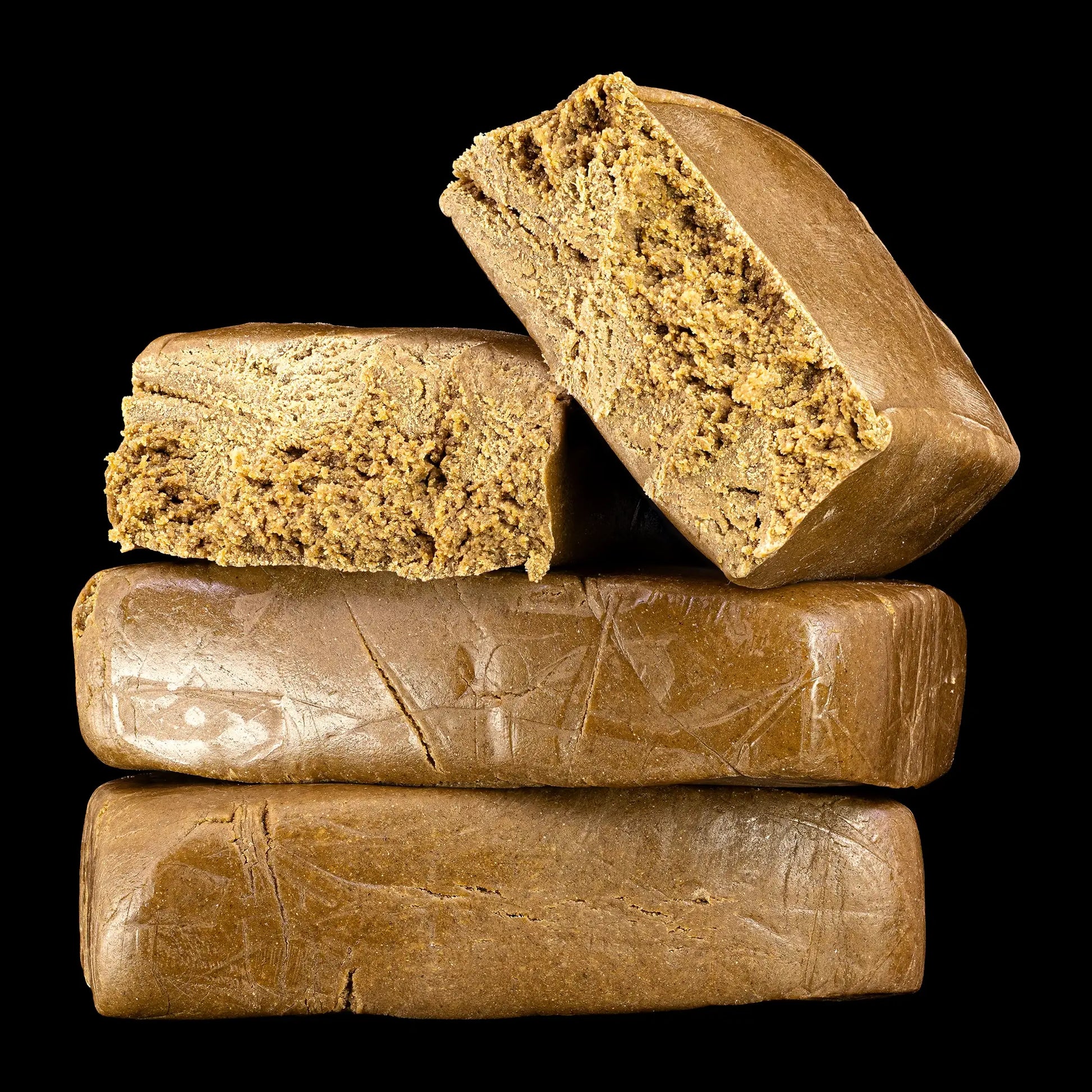 Stack of brown cannabis hash bars on a black background
