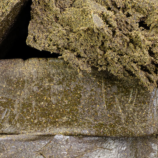 Close-up of stacked hash blocks with a textured surface manali cream thca