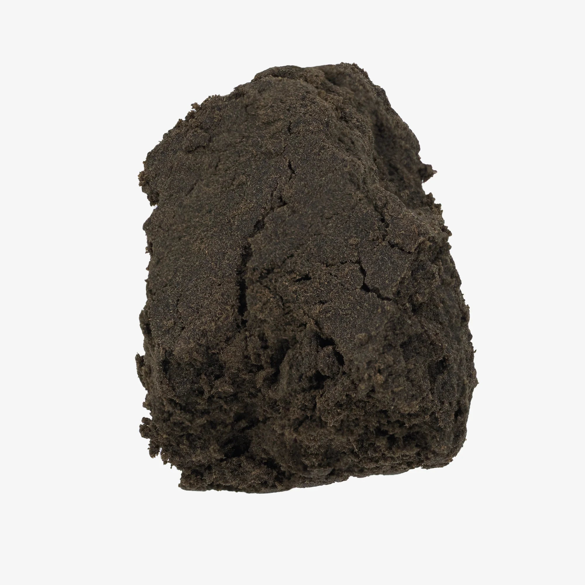 Formet klump af mørkebrun hash med kompakt og ensartet tekstur, fotograferet mod hvid baggrund.