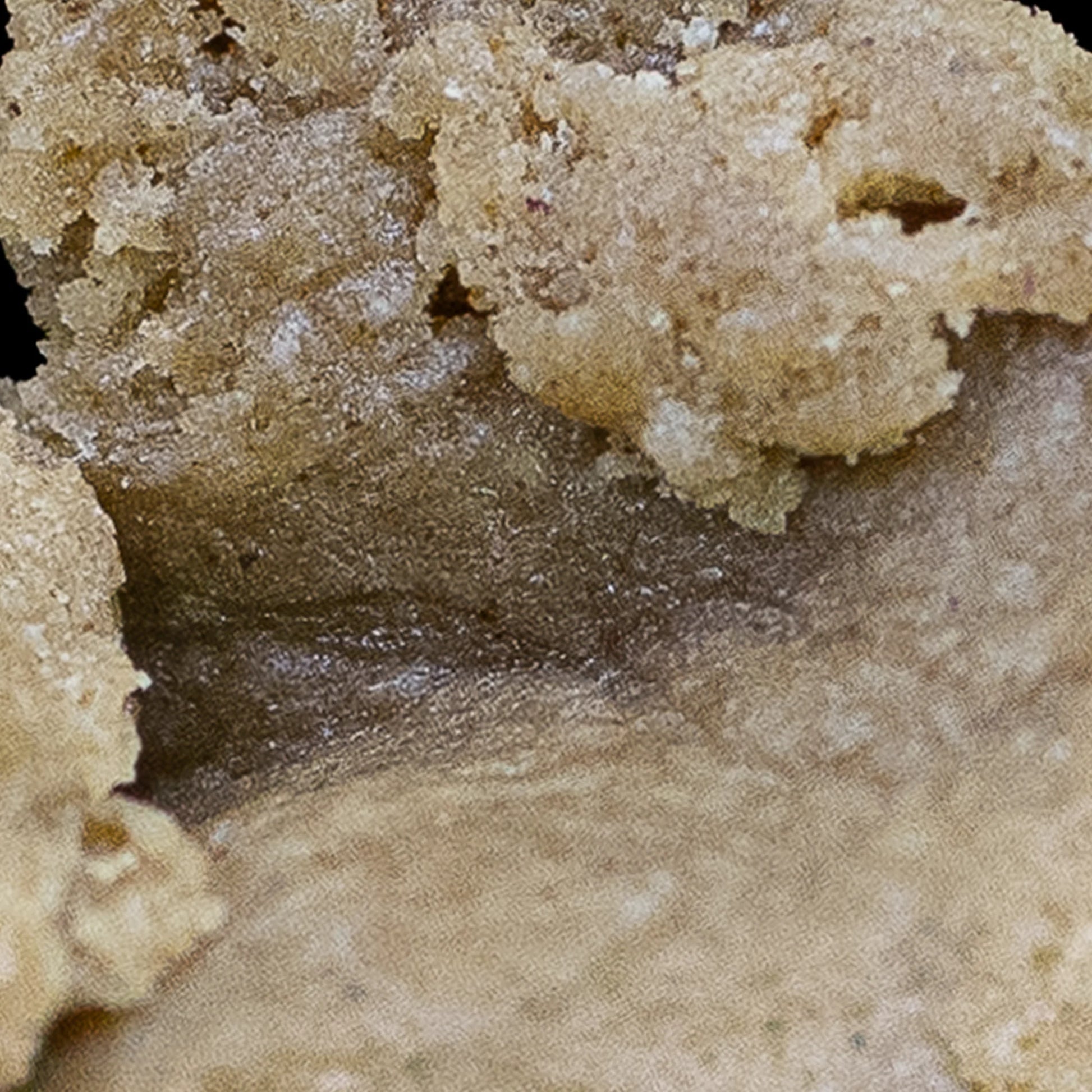 Nærbillede af Bubble Hash med lysebrun og gylden farve, der fremhæver den cremede, smørbare konsistens og fine trichomstruktur.