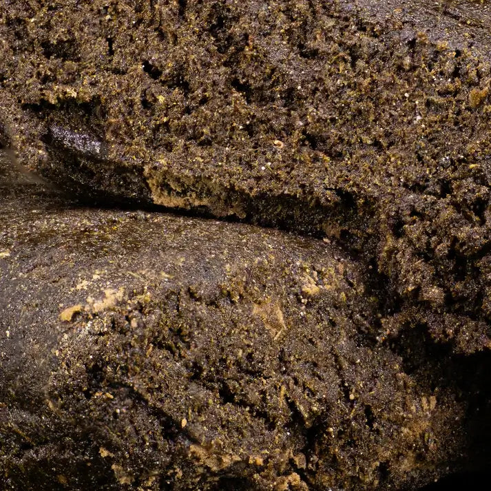 dark brown hash on a black background weedshop close up macro shot